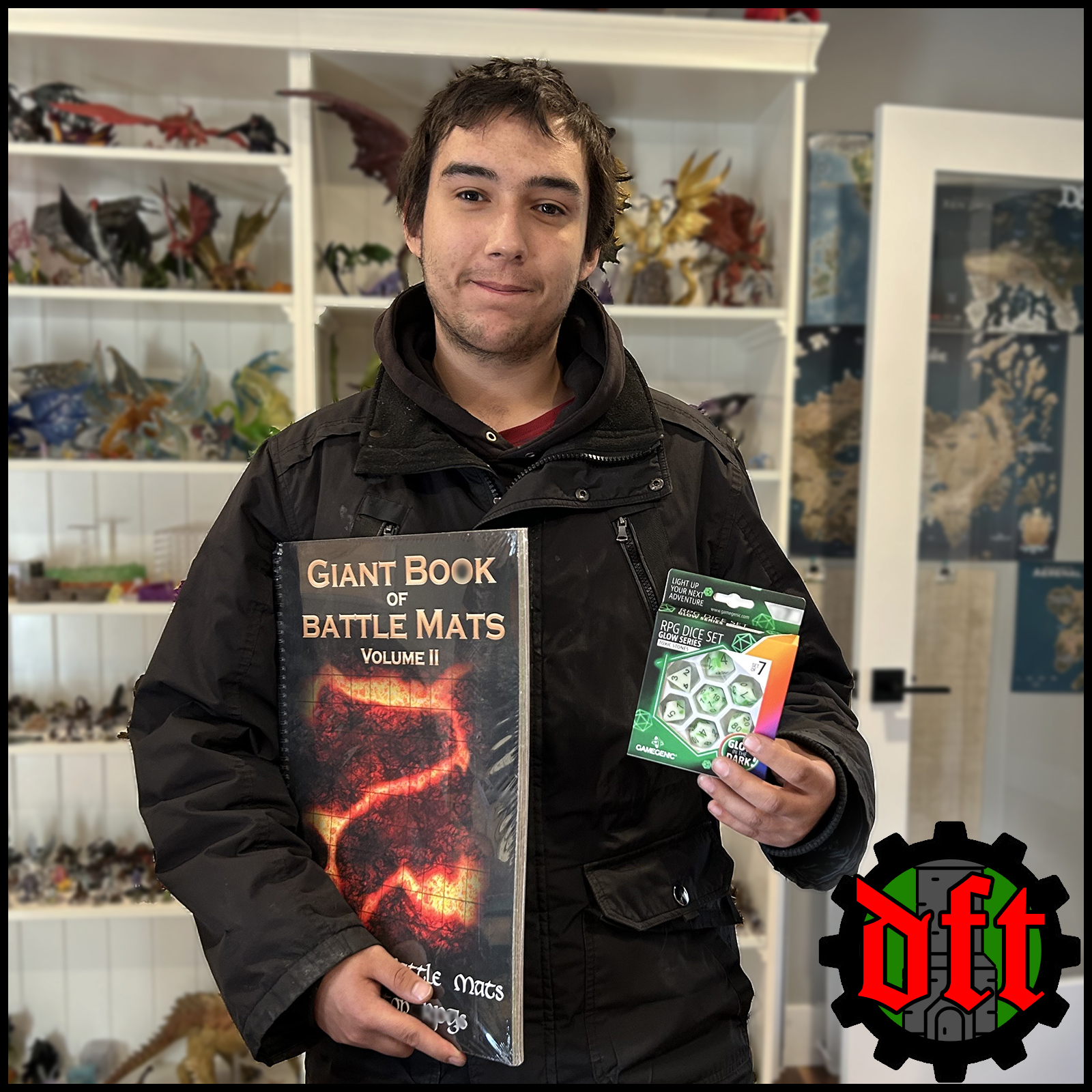 A.H. holding their Bag of Holding Winnings: a Giant Book of Battle Mats and a 7pc set of Glowing Green dice!